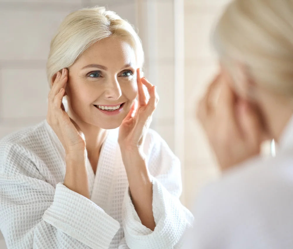 woman looking in the mirror looking beautiful after anti aging peel treatment