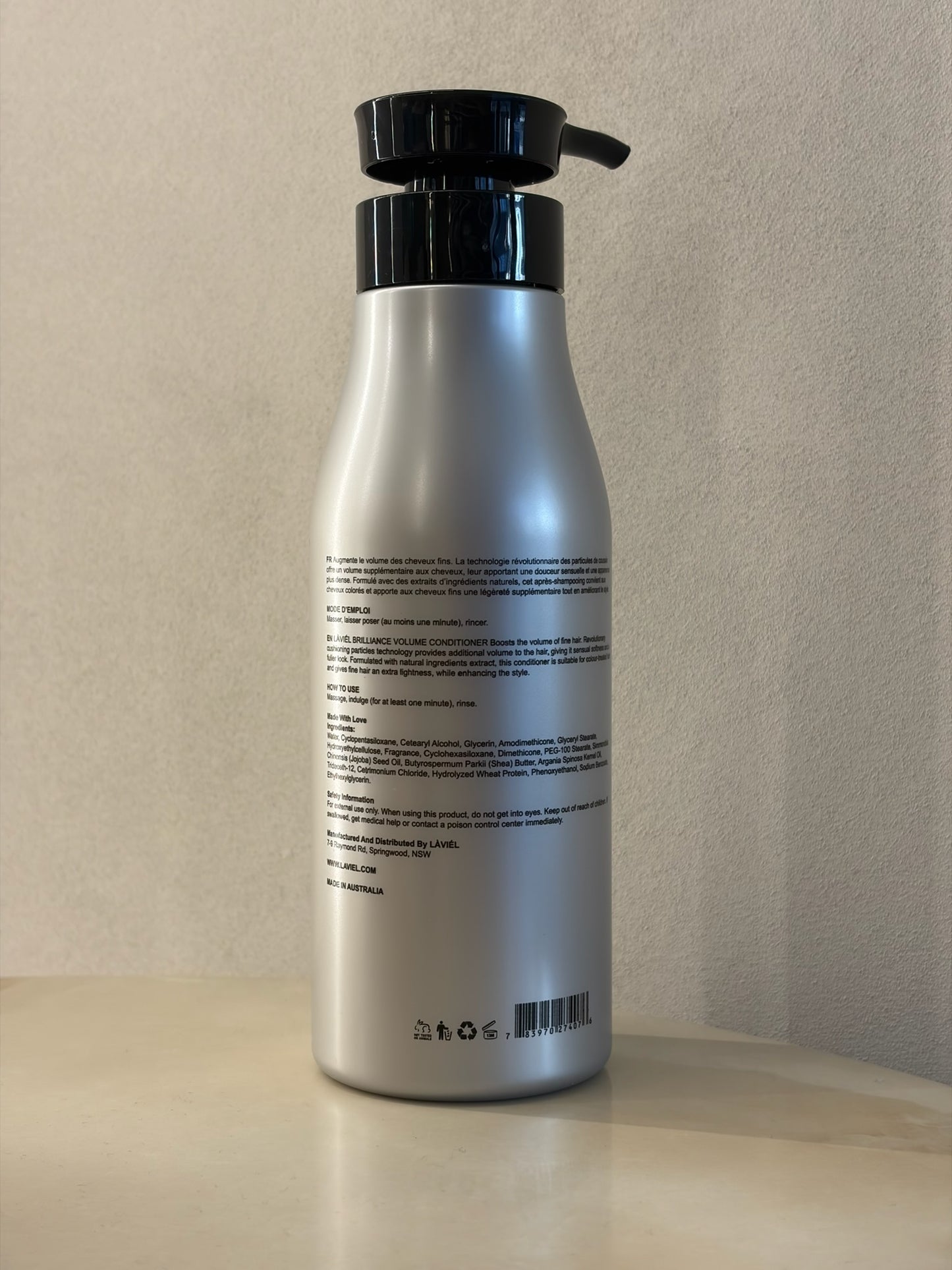 Silver bottle with black pump on a beige background